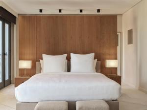 a bedroom with a large white bed with two lamps at The Chedi El Gouna in Hurghada