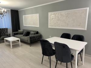 a living room with a table and chairs and a couch at ЛУКСОЗНИ АПАРТАМЕНТИ ДАРИС-free parking in Kazanlŭk