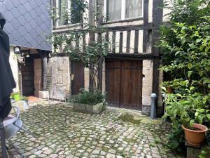 un vecchio edificio con una porta di legno e un albero di Le Cocon Douillet a Rouen