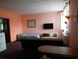 a living room with a couch and a tv at Šenk u Švejka in Ústí nad Labem