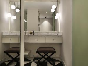 a bathroom with a sink and two stools under a mirror at The Chedi El Gouna in Hurghada