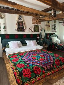 Un dormitorio con una cama con una manta colorida encima. en Pensiunea Casa Cezara, en Silvaşu de Jos