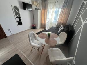 a living room with a table and a couch at Emmaia Escape Eforie Nord in Eforie Nord