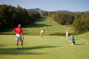 eine Gruppe von Menschen, die auf einem Golfplatz Golf spielen in der Unterkunft Killington Grand Resort Hotel in Killington