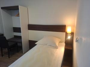 a bedroom with a bed and a desk and a lamp at Hotel Zens in Manderscheid