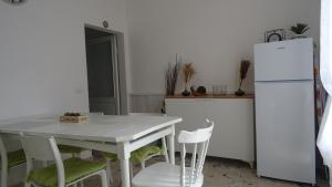 a kitchen with a white table and a refrigerator at Antica Acetaia in Carpaneto Piacentino