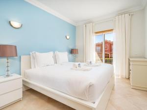 a bedroom with a large white bed with a window at Relax and golf at Boavista Golf Spa Resort #1968 in Lagos