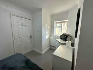 a small room with a kitchen with a microwave at Elohim Double Room in London