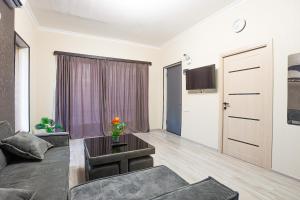 a living room with a couch and a table and a door at Brand-New 2BR House with Garden in Tbilisi City