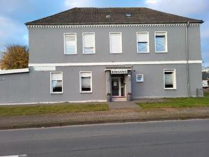 a gray building on the side of a street at Hostel Ellwürder Hof in Nordenham