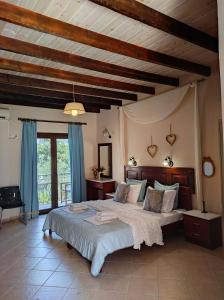 a bedroom with a large bed with blue curtains at Epavli Veneti in Parga
