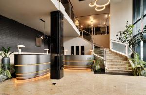 a lobby with a staircase and a stair case at Leonardo Royal Hotel Warsaw in Warsaw