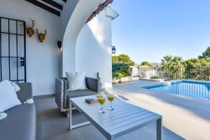 een woonkamer met een tafel en een glas wijn bij Villas Guzman - Olga in Moraira