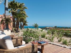 a patio with a table and chairs and the ocean at The Chedi El Gouna in Hurghada