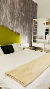 a bedroom with a large white bed with a green headboard at Habitación Plaza Zerolo A in Madrid