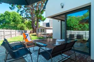 eine Terrasse mit Stühlen und einem Tisch auf einer Terrasse in der Unterkunft Happy Home - Charmante Maison Proche Plage in Saint-Gildas-de-Rhuys