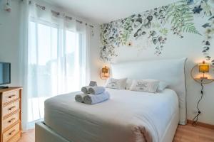 ein Schlafzimmer mit einem weißen Bett mit Handtüchern darauf in der Unterkunft Happy Home - Charmante Maison Proche Plage in Saint-Gildas-de-Rhuys