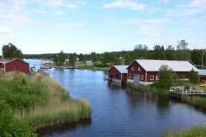 a body of water with houses and a river at Lodge åstön in Söråker