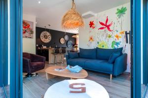 ein Wohnzimmer mit einem blauen Sofa und einem Tisch in der Unterkunft Happy Home - Charmante Maison Proche Plage in Saint-Gildas-de-Rhuys
