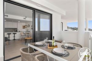 a white dining room with a table and chairs at Mimosa in Fuengirola +19 photos
