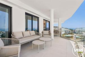 a living room with a couch and tables and windows at Mimosa in Fuengirola