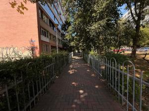 a brick sidewalk next to a fence next to a building at RENTeaza Studio IOR Park in Bucharest