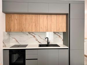 a kitchen with white cabinets and a sink at Talea Luxe Apartment in Tale +6 photos