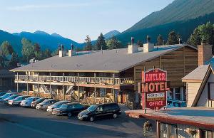 a motel with cars parked in a parking lot at Antler Inn in Jackson