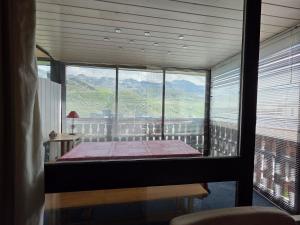 a bedroom with a large window with a view of a mountain at Le Serac Panoramic Mountain View spacious 40m2 managed by private host in Val Thorens