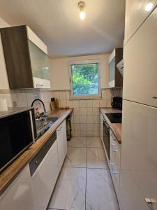 a kitchen with white appliances and a window at Wohnung Hochbild in Überlingen +5 photos