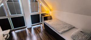 カルカーにあるFerienhaus Niederrhein Kalkarの2つの窓とソファのある部屋