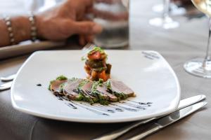 a white plate with a piece of food on a table at Rouge International Resort in Milano Marittima