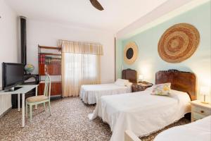 カルタヘナにあるEn el campo de Tallanteのベッド2台とテレビがあるホテルの部屋
