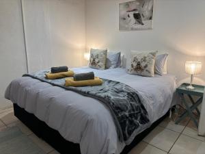 a bedroom with a large bed with two pillows at DullVino Wellington House in Dullstroom
