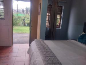 a bedroom with a bed and a view of a yard at Suburban Inn Bluff in Durban