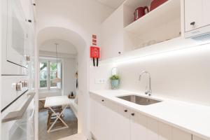 a kitchen with white cabinets and a sink at Casinha Amorosa in Faro +12 photos