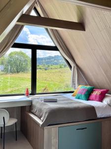 una cama en una habitación con una ventana grande en Hill House DOMEK "Hill House Apartamenty", en Białka Tatrzanska