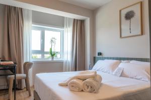a bedroom with a bed with towels on it at SNÖ Porta das Fragas in A Capela +59 photos