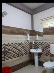 a bathroom with a sink and a toilet at Arara escpd homestay in Cherrapunji