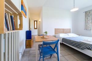 a bedroom with a bed and a table and a blue chair at Kalinifta - Io parto Io arrivo in Tricase