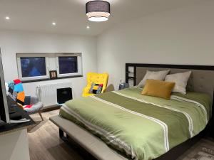 una camera con un grande letto e una sedia gialla di La Casa Nancy Tomblaine 12 pers Parking et Jardin a Tomblaine Altre 32 foto