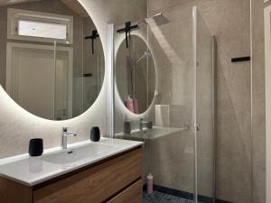a bathroom with a sink and a shower with mirrors at Living in a Nikolai Astrup motif 96m2 in Vassenden +45 photos