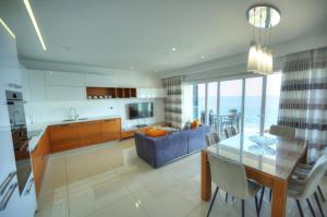 a kitchen and living room with a glass table at Large 3 bedroom with seafront balcony DDIF1-5 in Sliema