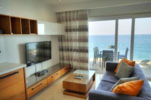 a living room with a blue couch and a television at Large 3 bedroom with seafront balcony DDIF1-5 in Sliema
