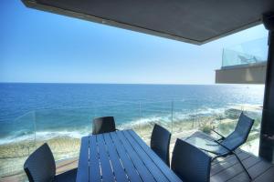 a dining table with chairs and a view of the ocean at Large 3 bedroom with seafront balcony DDIF1-5 in Sliema