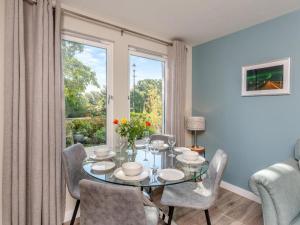 a dining room with a glass table and chairs at River views 5 mins from beach in Nairn