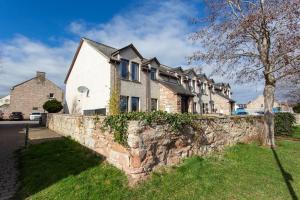 a row of houses behind a stone wall at River views 5 mins from beach in Nairn