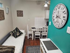 a living room with a clock on the wall at PinotageLuxuryCollection 16 Ryneveld Plaza in Stellenbosch