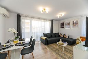a living room with a black couch and a table at Mountain Views Urban Plaza in Braşov