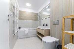 a bathroom with a toilet and a sink and a tub at Mountain Views Urban Plaza in Braşov +28 photos